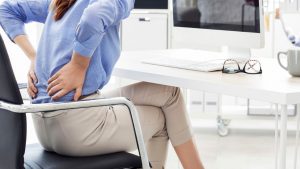 Mujer con dolor de espalda. Portada de artículo Ventajas de usar un corrector postural.