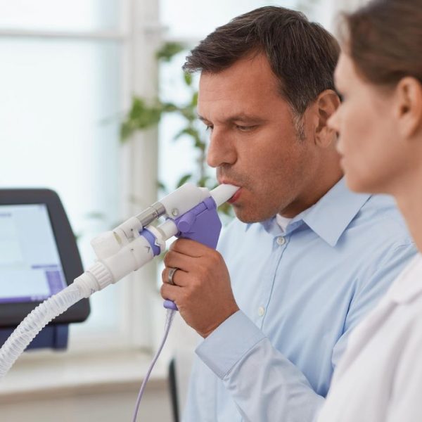 Paciente hombre con doctor mujer realizando una espirometría basal.